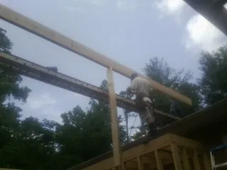 Carpenter setting a ridge beam over a new addition frame — Ice Dam Removal by Roofing Brothers in Manteno