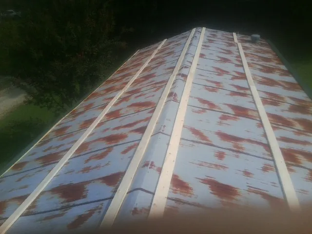 Rusted metal roof panels with new wood purlins before replacement — Storm Damage Roof Repair in Manteno by Roofing Brothers