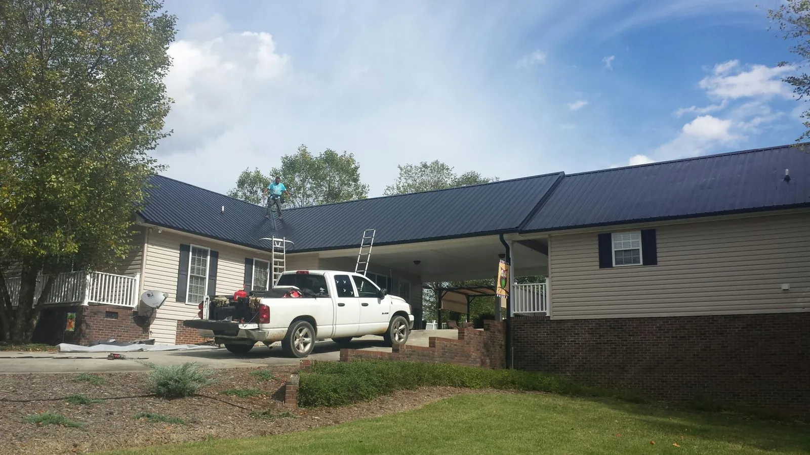 Black metal roof over a home and attached breezeway with ladders set in Manteno