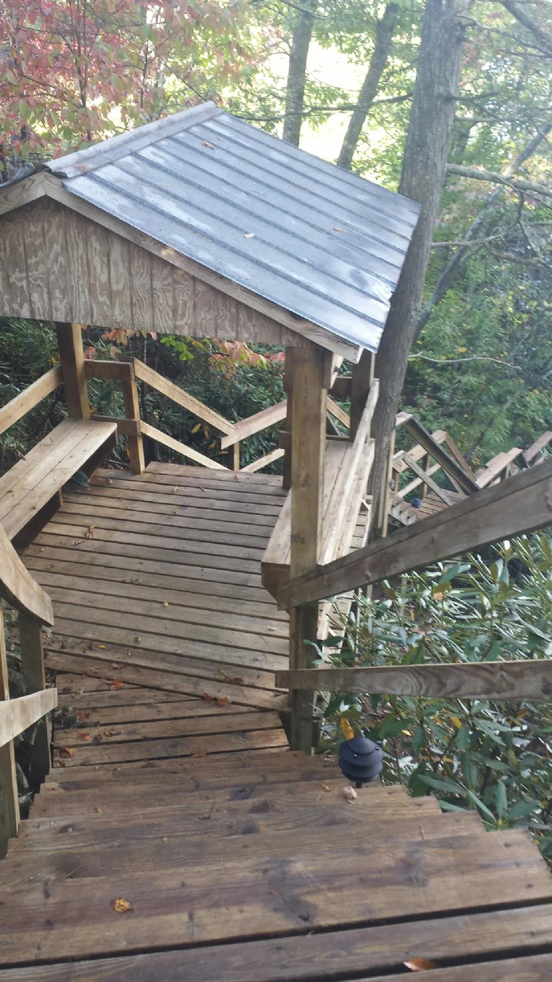 Metal roofed shelter over wooden steps on a wooded walkway — Skylight Repair & Installation work by our crew in Manteno