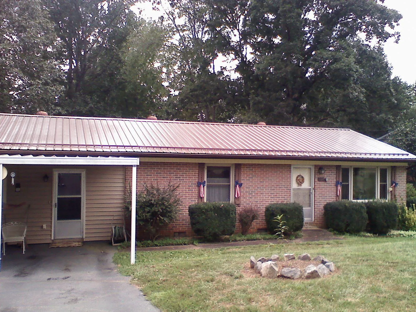 Bronze metal roof and carport on a brick ranch home — Roof Repair work by our crew in Manteno
